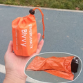 Sac de couchage de survie bivouac orange dans son sac de rangement compact